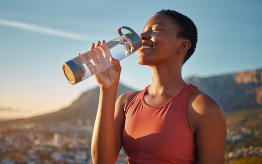 Frau trinkt Wasser nach Sport