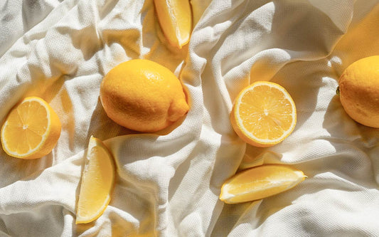 Zitronen in unterschiedlichen Formen auf einem weißen Tischtuch. 