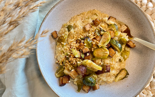 Rosenkohl-Risotto mit Tofu Haselnuss Crunch auf einem Teller